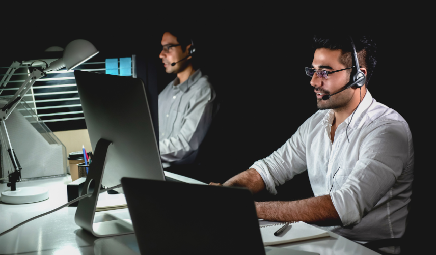 Programadores trabajando en sus portátiles sobre una mesa de madera